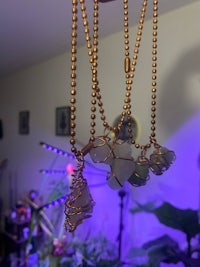 a group of sea glass necklaces hanging in a room